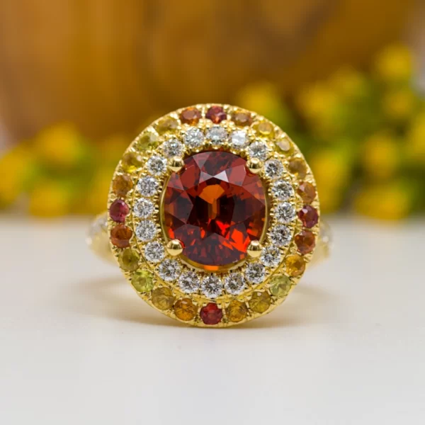 ring with a spessartite central stone with diamonds and degraded saphir frome yellow to orange